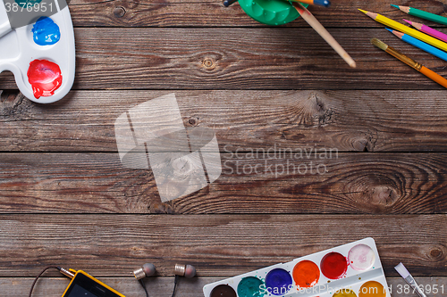 Image of Paper, watercolors, paint brush and some art stuff on wooden   table