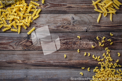 Image of Mixed dried pasta selection on wooden background.