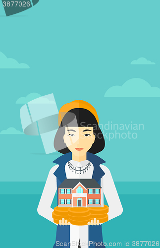 Image of Woman holding house model.