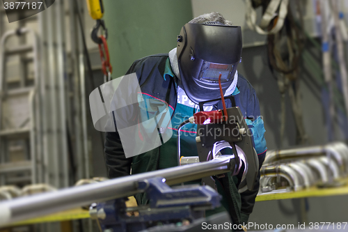 Image of Industrial worker setting orbital welding machine.