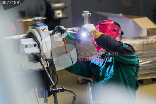 Image of Industrial worker welding in metal factory.