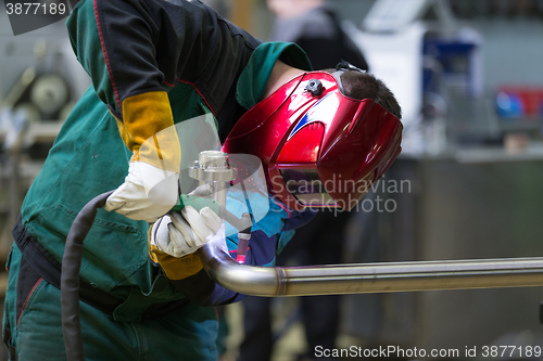 Image of Industrial worker welding in metal factory.