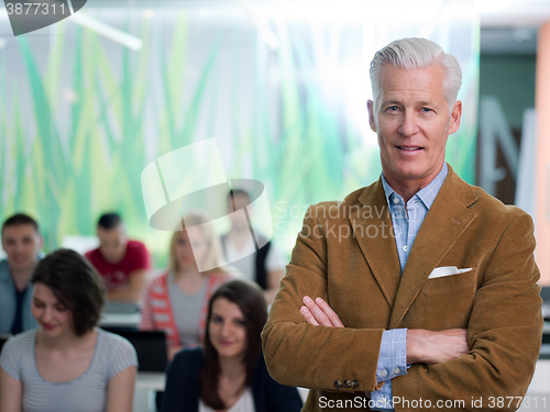 Image of portrait of in teacher in classroom with students group in backg