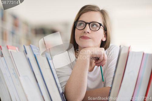 Image of portrait of famale student selecting book to read in library