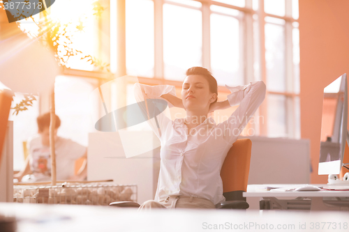 Image of young business woman relaxing at workplace
