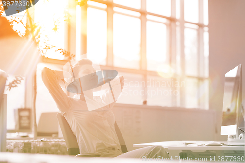 Image of young business woman relaxing at workplace