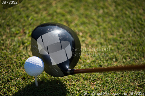 Image of top view of golf club and ball in grass