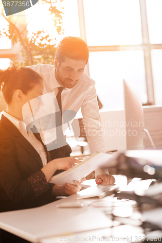 Image of business couple working together on project, sunrise in backgrou