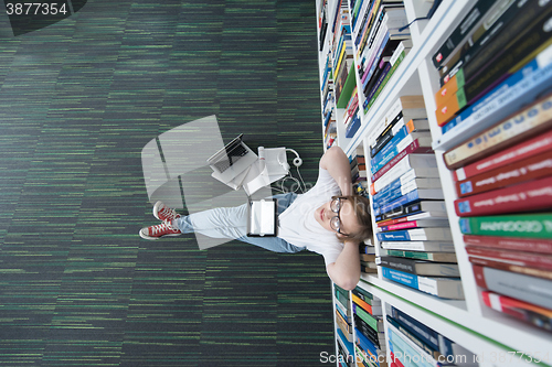 Image of female student study in library, using tablet and searching for 