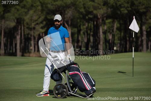 Image of golf player walking with wheel bag