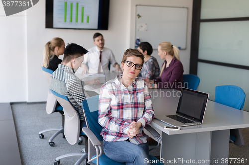Image of portrait of young business woman at office with team on meeting 