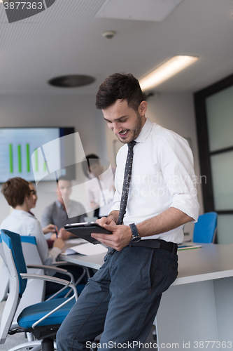 Image of young business man with tablet at office meeting room