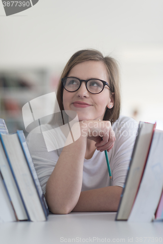 Image of portrait of famale student selecting book to read in library