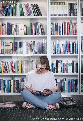 Image of famale student reading book in library