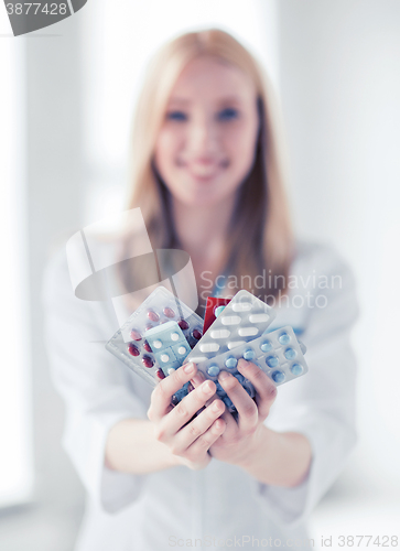 Image of female doctor with packs of pills
