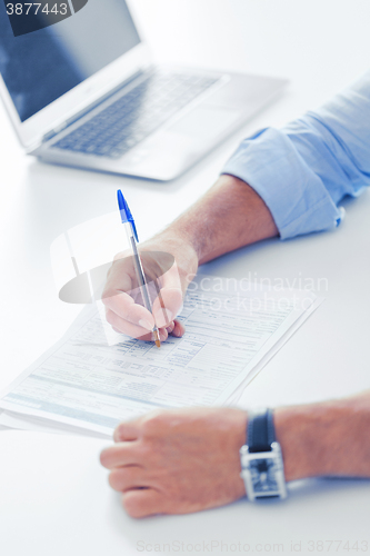 Image of man signing a contract