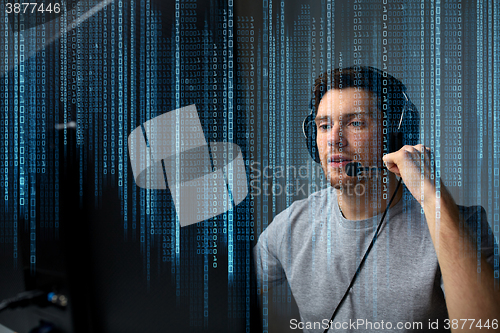 Image of man in headset playing computer video game at home