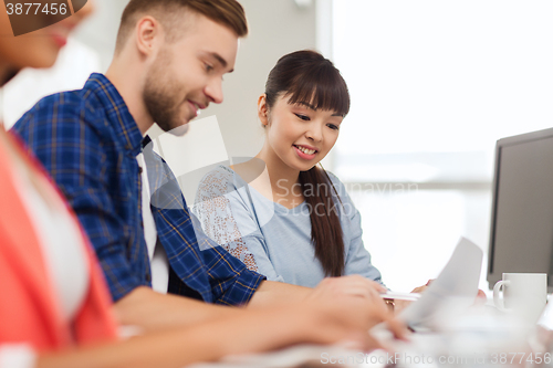 Image of happy creative team or students working at office