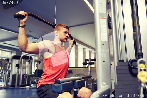 Image of man flexing muscles on cable machine gym