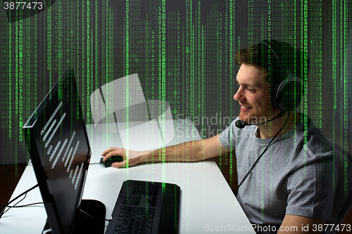 Image of man in headset playing computer video game at home