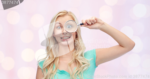 Image of happy young woman with magnifying glass