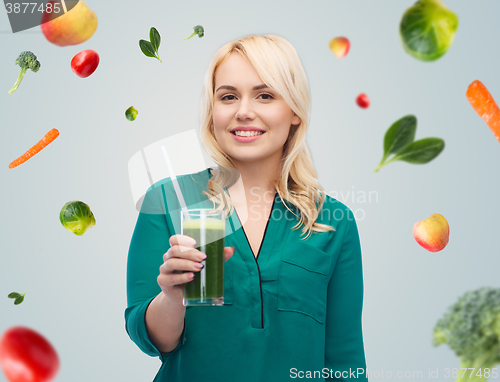 Image of smiling woman drinking vegetable juice or smoothie