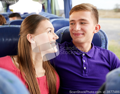 Image of happy teenage couple or passengers in travel bus