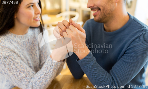 Image of happy couple holding hands at restaurant or cafe