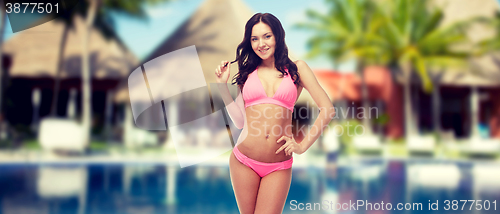 Image of happy young woman in pink bikini swimsuit on beach