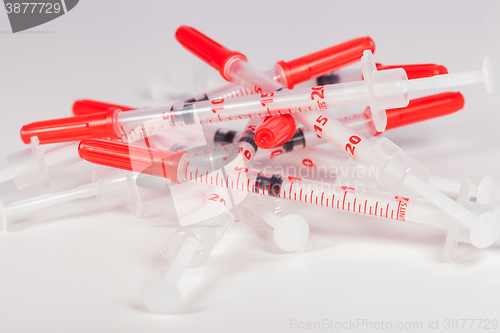 Image of Pile of Empty Syringes with Red Safety Caps