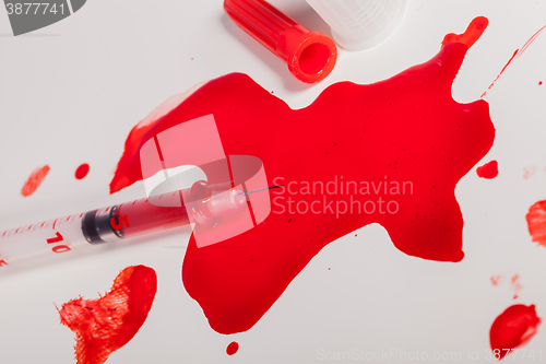 Image of Syringe Squirting Red Blood onto White Background