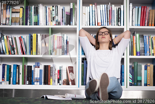 Image of female student study in library, using tablet and searching for 