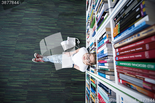 Image of female student study in library, using tablet and searching for 