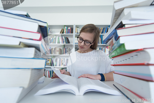 Image of female student study in library, using tablet and searching for 