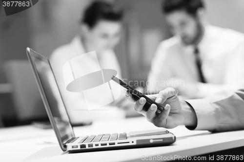 Image of close up of  businessman hands  using smart phone on meeting