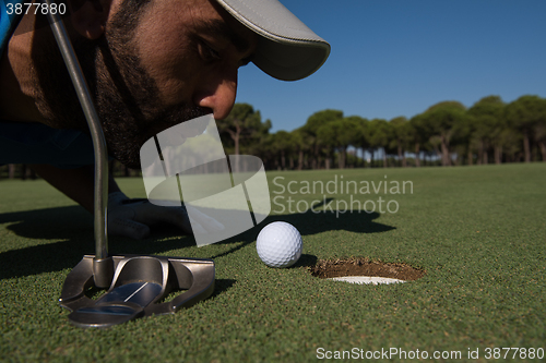 Image of golf player blowing ball in hole