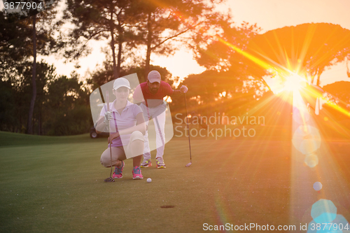 Image of couple on golf course at sunset