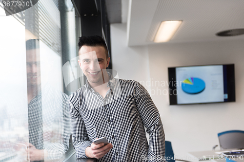 Image of young business man using smart phone at office