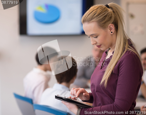 Image of blonde businesswoman working on tablet at office