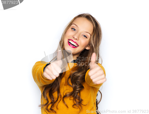 Image of happy young woman or teen girl showing thumbs up