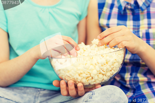 Image of close up of kids with popcorn bowl eating