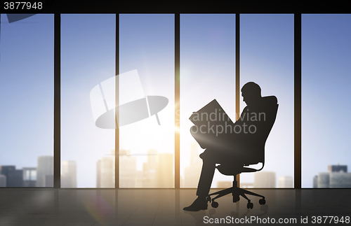 Image of silhouette of businessman reading documents