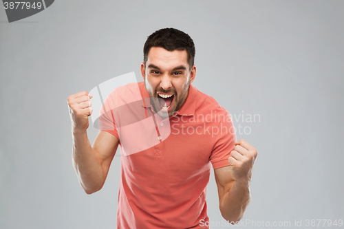 Image of happy man celebrating victory over gray background