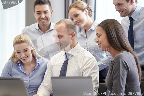 Image of smiling business people with laptop computer