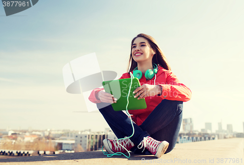 Image of happy young woman with tablet pc and headphones