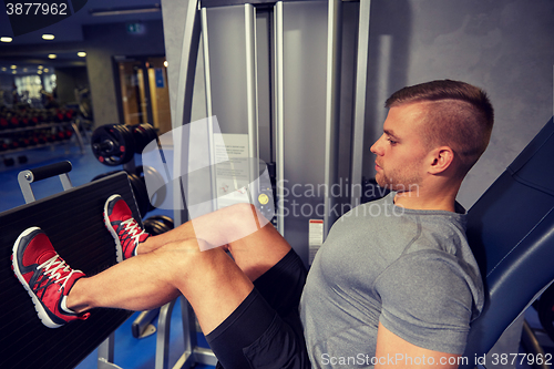 Image of man flexing leg muscles on gym machine