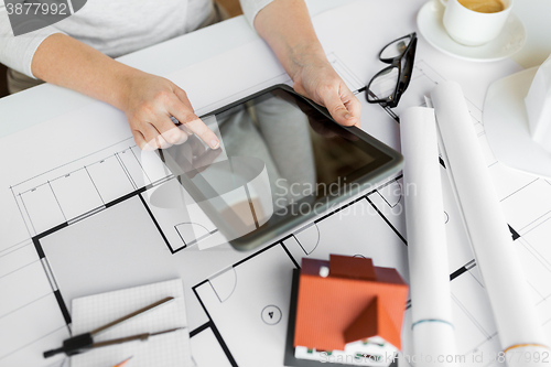 Image of close up of hand with blueprint and tablet pc