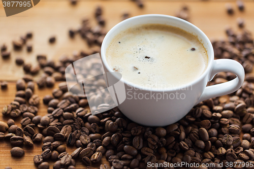 Image of close up coffee cup and grains on wooden table