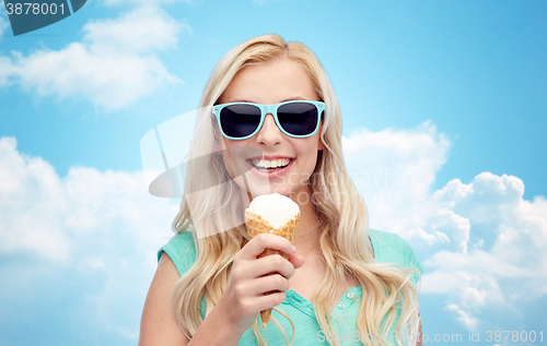 Image of happy young woman in sunglasses eating ice cream