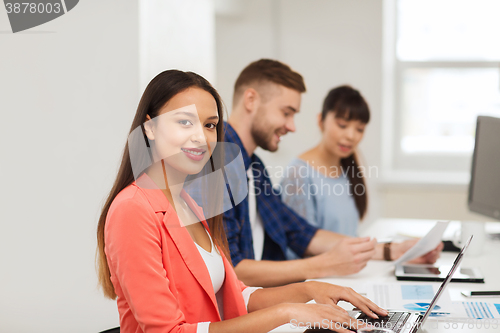 Image of happy african woman over creative team at office